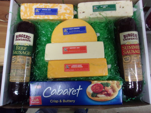Cheese and Meat Lovers, gift box with cheeses, meats and a box of crackers with grass on a table