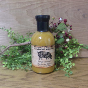 Tangy Mustard Barbecue Sauce bottle, Osceola Cheese sauce on a table