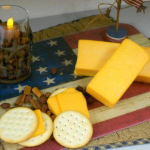 Hickory Smoked Sharp Cheddar cheese blocks on a cutting board on a table