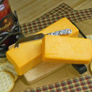 Hickory Smoked Horseradish Cheddar cheese blocks on a cutting board on a table