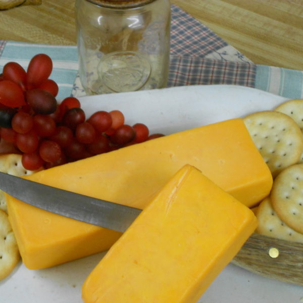 6 Month Sharp Cheddar Medium, cheese blocks on a plate on a table on a table