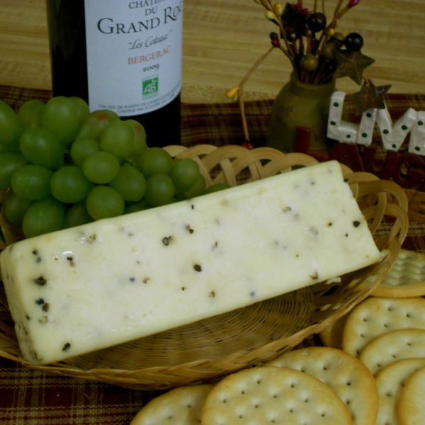 Hickory Smoked Black Pepper Monterey Jack cheese block in a basket on a table
