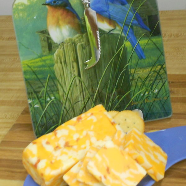 Hickory Smoked Cheddar Jack with Pepperoni cheese blocks and slices on a plate on  table
