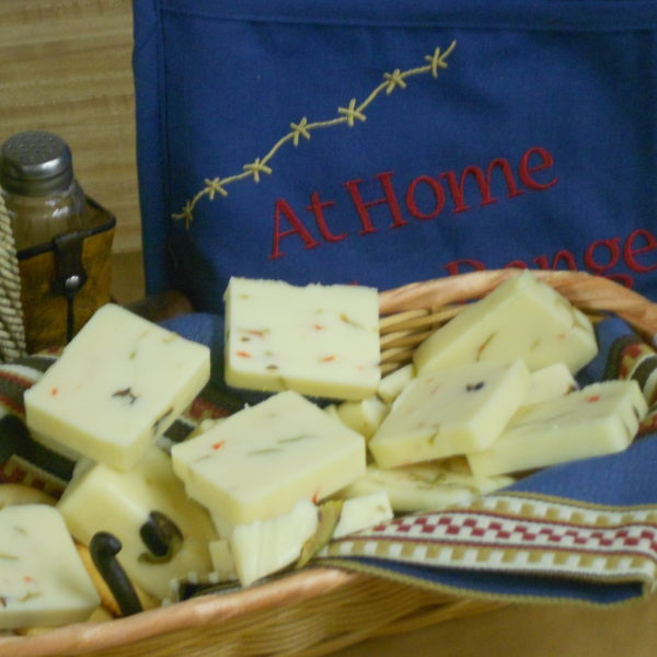 Green Olive Cheddar cheese blocks in a basket on a table