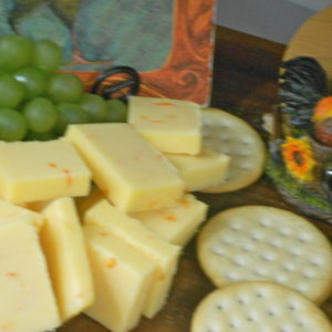 Mild Buffalo Wing Cheddar cheese blocks on a cutting board on a table