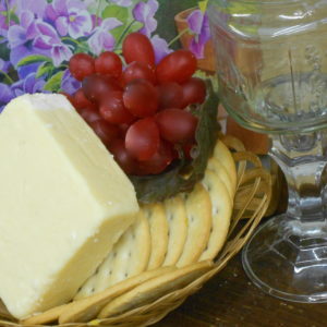 Hickory Smoked 10 Year Aged Cheddar cheese block in a basket on a table