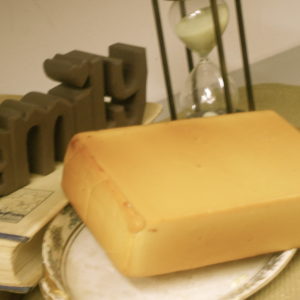 Smokey Swiss and Cheddar cheese block on a plate on table