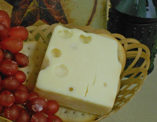 Extra Sharp Aged Swiss cheese block in a basket on a table